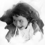 Close up of a child with curly hair, a brace placed around the shoulder and chest posing for the camera. Portrait of a Child, Circa 1955
