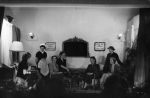 Long shot of women in a lounge room stage setting. Two are standing, the others sitting. There is a mirror on the wall in the middle of the shot and windows on either side of the room. Pantomime at the Hospital, Circa 1955