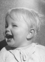 Close up of an infant looking towards the left posing for the camera. Portrait of a Child, Circa 1955