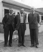 Long shot of three men dressed in suits standing outside in front of a building. Uncle Bobs Club, Circa 1955