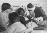 Close shot of three young patients receiving presents from Father Christmas. Father Christmas at the Hospital, Circa 1955