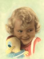 Close shot portrait of a young child holding a toy duck. Photograph appears to have been hand coloured in paint. Child with Toy, Circa 1955