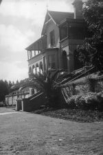 Long shot of a two story building taken to the side. Entrance to the Hospital, Circa 1955