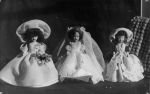 Long shot of three dolls one in a wedding attire with veil the other two in long dresses and hats Dolls, Circa 1955