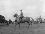 Long shot taken from the side of a person riding a horse. At the Races, Circa 1955