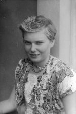 A medium shot of a young woman, with short hair, who is smiling for the camera. Portrait of a Child, Circa 1955