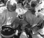 A close up shot of two young children sitting down. Child on the right of photograph is wearing a pirate style hat with a skull & crossbones on the front. Child on the left is also wearing a hat. Birthday Celebrations at the Hospital, Circa 1955