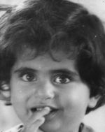 A close up shot of a young child looking at the camera. Child has short dark hair. Portrait of a Child, Circa 1955