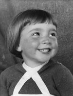 Medium shot of a child seated with braces fitted around neck and chest looking to side posing for the camera. Portrait of a Child, Circa 1955