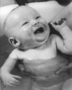 A close up shot of an infant being given a bath. Bath Time, Circa 1955