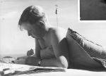 Medium shot of a young person outside laying prone on a mattress reading a newspaper wearing a watch. Reading the Newspaper, Circa 1955
