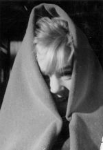 Close up shot of a young child, smiling, wrapped in a blanket. The child's face is partially visible. Portrait of a Small Child, Circa 1955