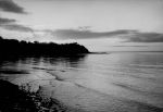A long shot of the sea showing a headland to the left. View of the Sea, Circa 1955