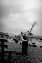 A long shot outside of a man holding some sort of stick in his hands and pointing it up into the air. On the end of the stick is what looks like an air filled bag. Can You See it?, Circa 1955