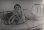 Smiling Child Sitting on a Bed, Circa 1930 Smiling Child Sitting on a Bed, Circa 1930