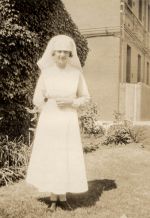 Long shot of a staff member standing in the garden. Nurse Standing in Front of Hospital, 1922