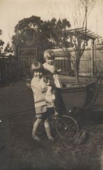 Long shot of two small children playing with a cat and a pram Children playing with a Cat and Pram, Circa 1922