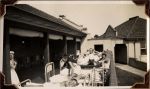 Long shot of patients on hospital beds and a staff member standing underneath the verandah. Heliotherapy at Frankston, Circa 1941
