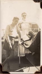Long shot of a staff member with two children. One child is standing next to the bed while another child is laying down on the verandah. Trees are visible in the background. Nurses with Patient, Circa 1941