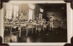 Long shot of interior hospital room. Staff members are present and patients are in beds. Ward Scene, Circa 1941