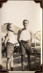 Long shot of two patients standing outside, hospital beds and exterior of building are in the background. Patients in Plaster, Circa 1941