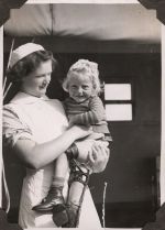 Nurse holding child with leg brace, Circa 1943 Nurse holding child with leg brace, Circa 1943