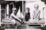 Three children outside on bed, Circa 1943 Three children outside on bed, Circa 1943
