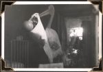 Long shot of a toy stork carrying a baby in a sheet tied around it's beak. The stork appears to be a similar size to that of the tall adult hospital staff. There is a crib, a window and flowers seen in the background. Stork, Circa 1945