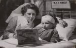 Medium shot of a staff member sitting at the bedside reading a book with a young child. Story Time, Circa 1945