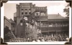 Long shot of outside of building with hospital staff visible on balconies & stairways. People and vehicle visible in foreground standing in front of building. Welcoming Home Prisoners of War, Circa 1945