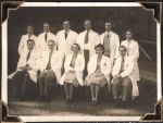 Long shot of men and women Doctors taken outside. They are in two rows with the front row seated and the back row standing. Staff Portrait, Circa 1945