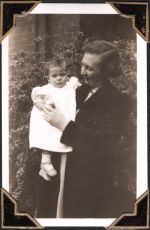 Medium shot of woman standing in garden, holding infant on right hip. Holding a Patient, Circa 1945
