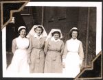 Medium shot of four staff members standing side by side outside building. Nurses Portrait, Circa 1945