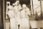Long shot of two Nurses standing holding infants in front of the balcony posing for the camera. Nurses Holding Babies, 1928