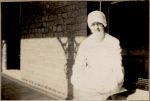 A medium shot of a nurse sitting outside on a window ledge. Portrait of a Nurse, 1928