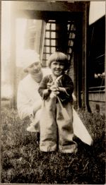 A long shot of a Nurse kneeling on the grass with a child. Nurse and Child, 1928