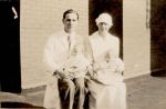 A medium shot of a Doctor and a Nurse sitting outside a building, each nursing a baby on their laps. Staff Holding Infants, 1928