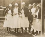 A long shot of six Nurses standing outside, five with their capes on. Nurses in the Hospital Grounds, 1928