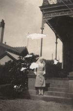 A long shot of a Nurse standing outside on the steps of a building. Nurse Posing on Steps, 1928