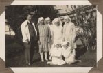 A long shot of four Nurses standing with a Doctor and two Nurses sitting on the grass in the garden. Staff on the Lawn, 1928