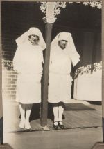 A long shot of two nurses standing on either side of the pole of a verandah. Two Nurses, 1928