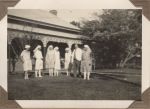 A long shot of six Nurses and a Doctor standing in the garden in front of a building. Staff on the Lawn, 1928
