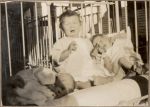 Medium shot of three infants in a cot outside posing for the camera. Crying Infants, 1928