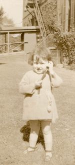 Long shot of a young patient standing outside posing for the camera. Child Playing on Lawn, 1928