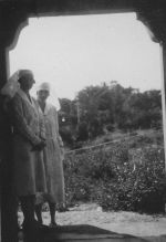 Long shot of two Nurses standing outdoors underneath an archway posing for the camera. Nurses, Circa 1940