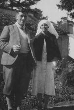 Long shot of a Nurse standing outdoors with a man posing for the camera. Staff Members, Circa 1940