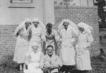 Long shot of a group of medical staff standing and seated outdoor posing for the camera. Staff Photo, Circa 1940