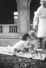 Long shot of two infants seated outdoors overseen by a Nurse. Children on the Lawn, Circa 1940
