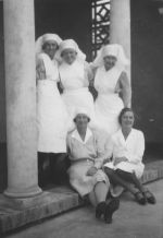 Long shot of five Nurses standing under an archway posing for the camera. Nurses, Circa 1940