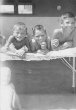 Medium shot of three children lying in a cot posing for the camera. Smiling Children, Circa 1940